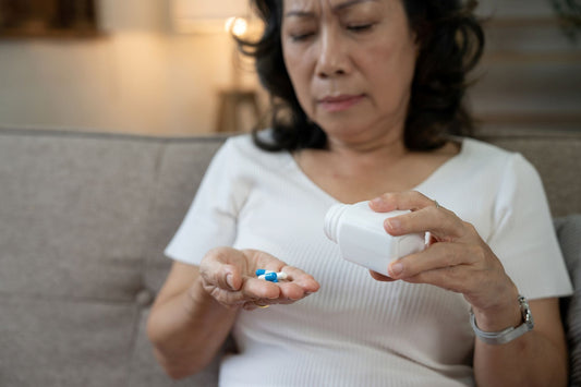 unhappy senior woman holding expensive prescription medication in hand