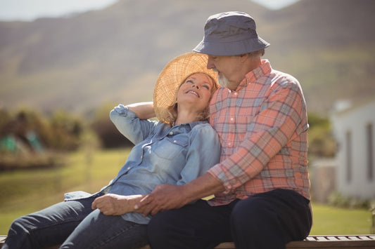 smiling senior couple sitting outside enjoying sun's embrace